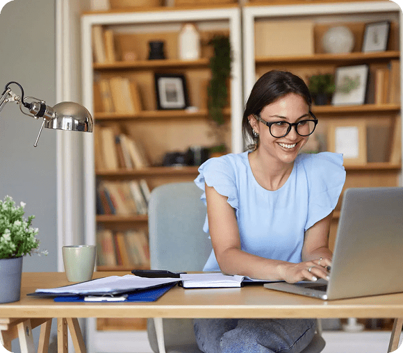 Smiling woman working on laptop at desk