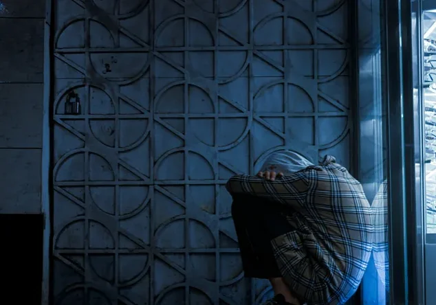 Person crouched beside illuminated eyeglasses display