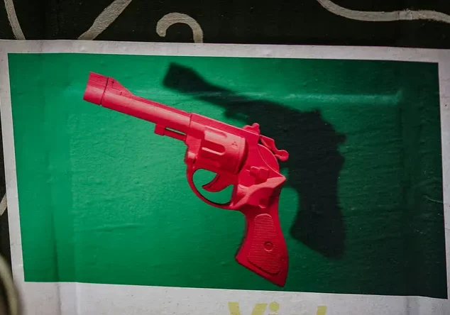 Red toy revolver on green background